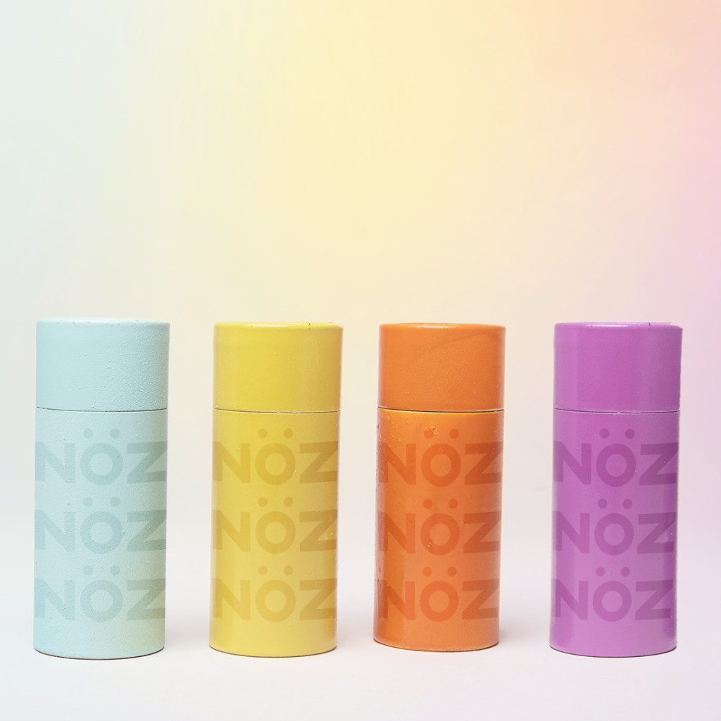 Four containers of Nözscreen. The colors include: Blue, Yellow, Orange, and Purple.